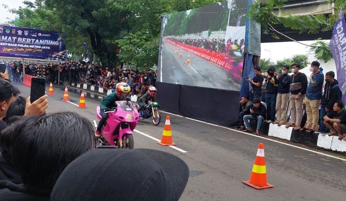 Para joki saat melakukan balapan dalam ajang street race di Ancol, Jakarta Utara, Minggu (16/1/2022).