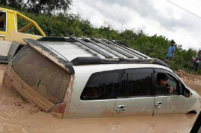 Toyota Kijang Innova mencoba melewati jalan berkubang di Kecamatan Kotawaringin Lama, Kalimantan