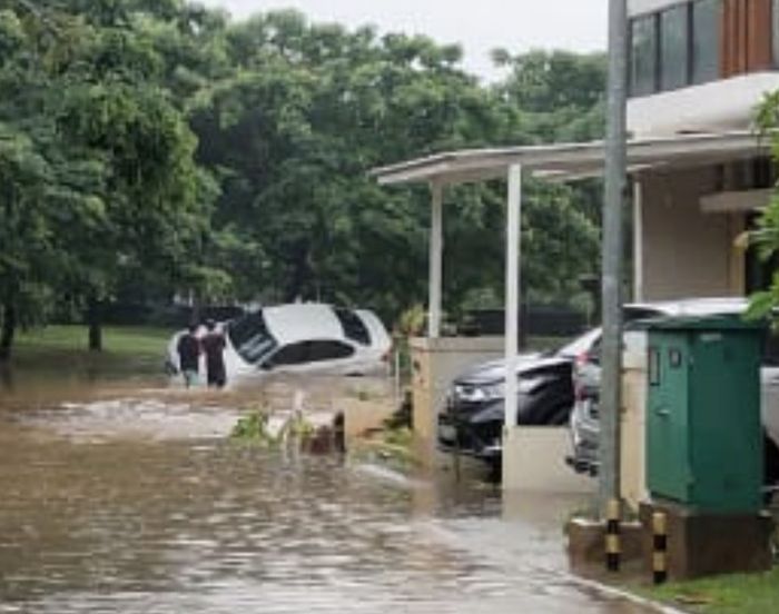 BMW 320i yang hanyut terseret banjir nampak bersandar pada sebuah pohon