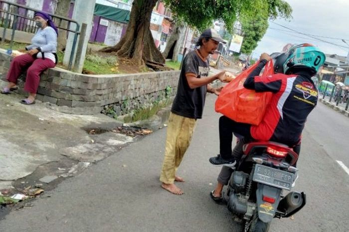 Para member ARCI Bogor Chapter membagikan nasi bungkus kepada masyarakat yang membutuhkan.