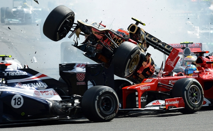 Romain Grosjean (tengah) diganjar larangan membalap karena menyebabkan tabrakan besar di F1 Belgia 2012.