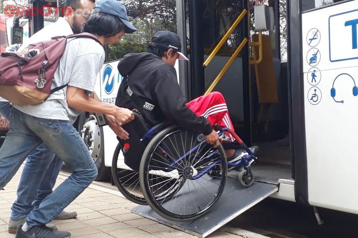 Ilustrasi atlet Para Games masuk ke bus Trans Jakarta
