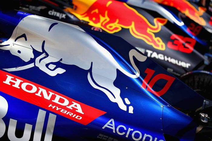 Mobil F1 Toro Rosso tahun 2018 berwarna biru terang, di sebelahnya mobil Red Bull dengan kelir biru gelap
