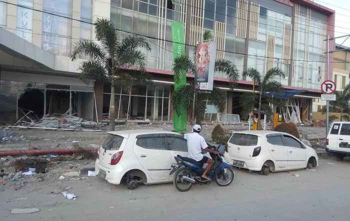 Mobil yang terparkir tampak kehilangan roda pasca gempa dan tsunami di Sulawesi Tengah