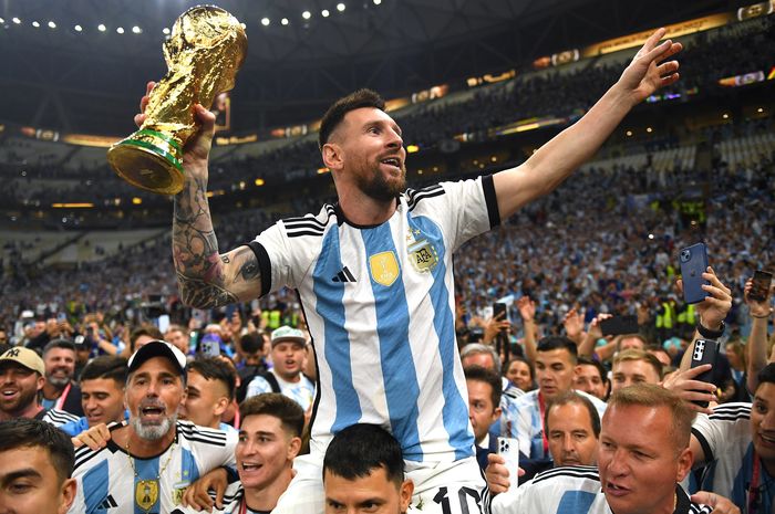 Lionel Messi mengangkat trofi Piala Dunia 2022 Qatar setelah timnas Argentina menjadi juara dengan mengalahkan timnas Prancis