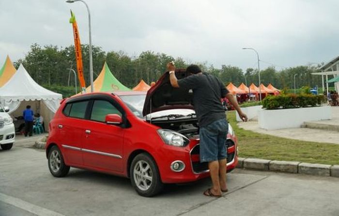 Ilustrasi pengemudi melakukan pengecekan kondisi mobilnya di rest area Tol Trans Jawa