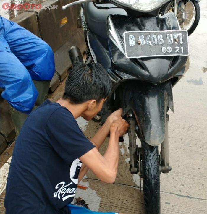 Para mekanik membantu bikers menyalakan motornya