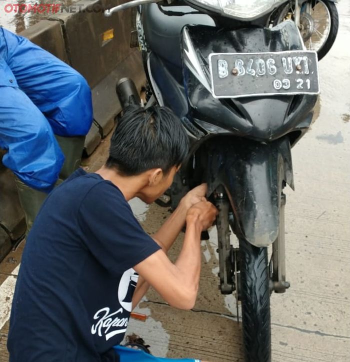 Para mekanik membantu bikers menyalakan motornya