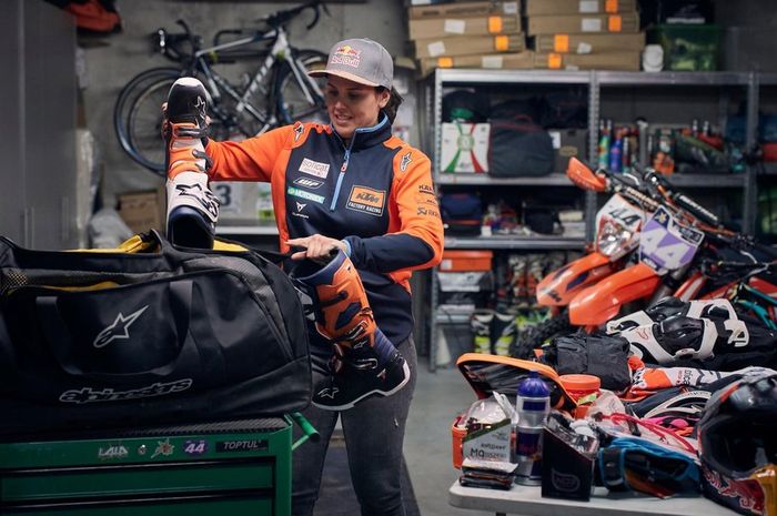 Laia Sanz tengah memasukkan sepatu boot yang akan dipakainya di Reli Dakar 2019