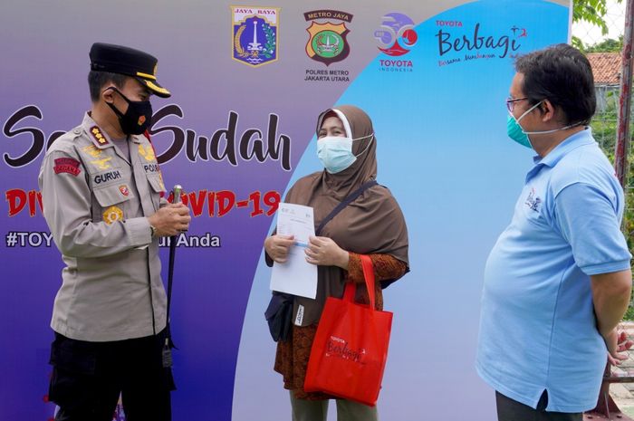Toyota Indonesia Sediakan 76.500 Dosis Vaksin COVID-19 untuk Program Vaksinasi Massal Gratis--- Kapolres Metro Jakarta Utara Kombes Pol. Guruh Arif Darmawan (kiri) tengah berbincang dengan salah satu warga penerima vaksin saat meninjau pelaksanaan vaksinasi COVID-19 gratis bagi warga Sunter