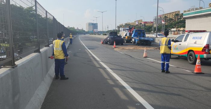 Anggota kepolisian melakukan olah TKP kecelakaan Ferrari Purosangue di Tol Cengkareng, Jakarta Barat