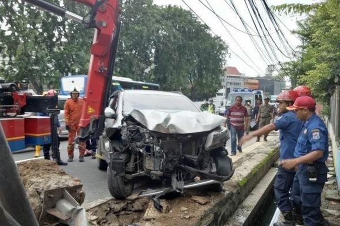 Petugas saat mengevakuasi mobil yang menabrak dan terperosok ke dalam saluran air di Jalan Suryopranoto, Kelurahan Petojo Utara, Gambir, Jakarta Pusat pada Senin (4/2/2019) 