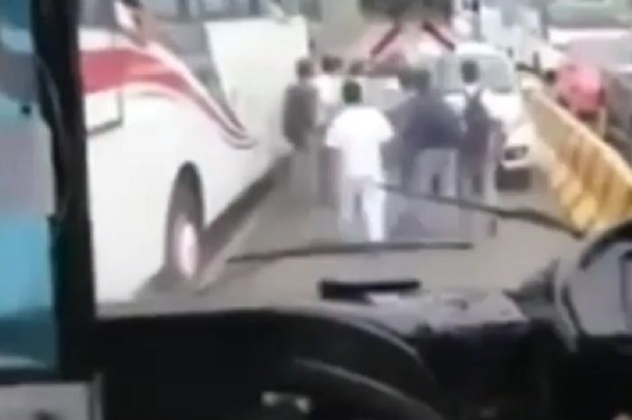 Penumpang bus menggirin mundur mobil lawan arus di gerbang tol Karawang Timur