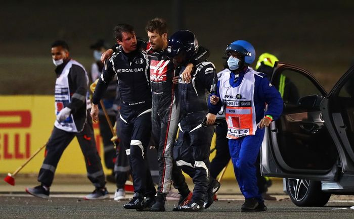 Romain Grosjean mendapat pertolongan petugas medis FIA dan petugas sirkuit setelah kecelakaan di lap pertama F1 Bahrain 2020