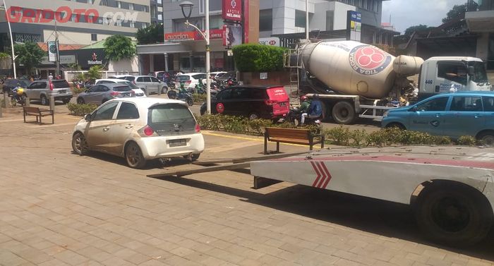 Honda Brio hendak diangkut ke mobil towing setelah terendam banjir di Kemang, Jakarta Selatan