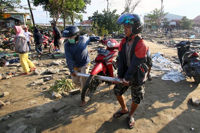 Sejumlah warga mengevakuasi motor pasca kejadian gempa dan tsunami di Donggala, Palu, Sulsel