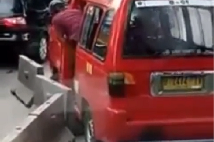 Angkot berusaha keluar dari jalur busway, namun justru ini yang didapatkan