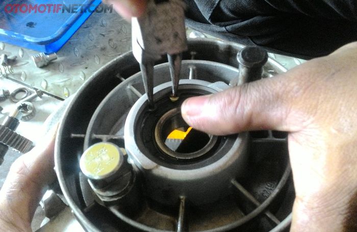 Posisi sil ada di sisi dalam, di balik bearing laher as roda Vespa LX 150ie. Jadi harus melepas bearing ini dulu dengan menyopot ring spi pengancingnya