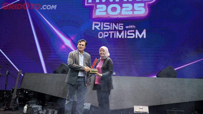 Rina Listiani, Senior Manager Corporate Communication PT Astra Honda Motor saat menerima piala dari Haryadi Hidayat, Managing Editor Tabloid OTOMOTIF di OTOMOTIF Award 2025