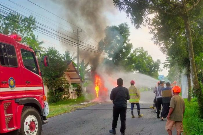 Petugas Damkar sedang memadamkan api dari Suzuki Vitara yang terbakar di Jalan Kaliurang, Sleman