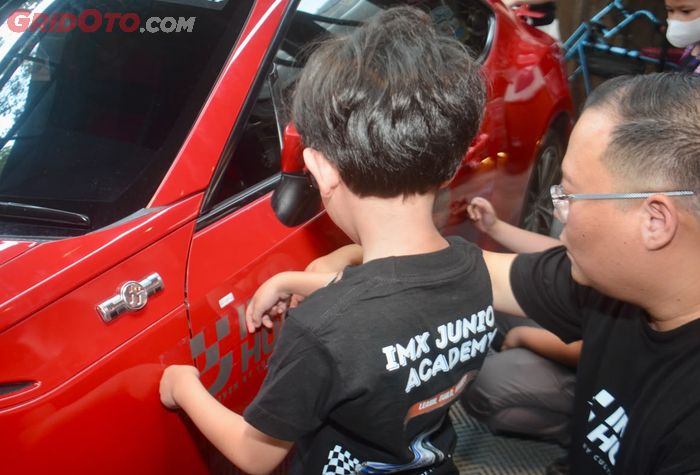 Momen peserta IMX Junior Academy saat melakukan pemasangan sticker pada mobil