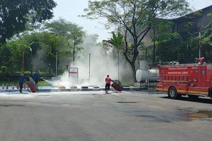 Petugas memadamkan api yang menyembur keluar dari tangki Pertalite di SPBU Sumur Buang, Jl Soekarno-Hata, desa Kaduagung, Cibadak, Lebak, Banten
