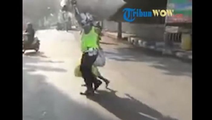 Seorang Polisi menolong nenek menyeberangi jalan