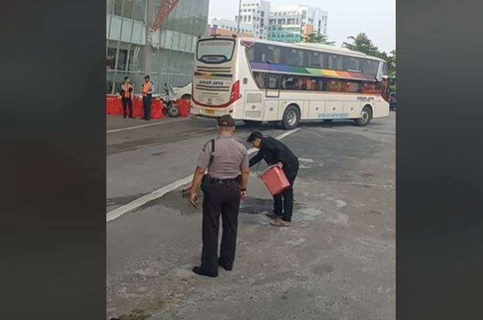 Penumpang bus yang dihukum membersihkan aspal terminal Terpadu Pulo Gebang, Jakarta Timur karena buang air kecil di toilet bus yang berhenti