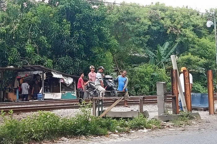 Jasa angkat motor seberangi rel kereta di desa Telaga Asih, Cikarang Barat, kabupaten Bekasi dekat stasiun Cibitung