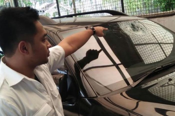Polisi menunjukan kaca mobil yang pecah akibat lemparan batu di jembatan Pesanggrahan, Kembangan, Jakarta Barat 