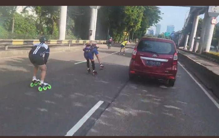 Rombongan sepatu roda berjalan di tengah jalan raya Gatot Subroto, Jakarta Selatan.