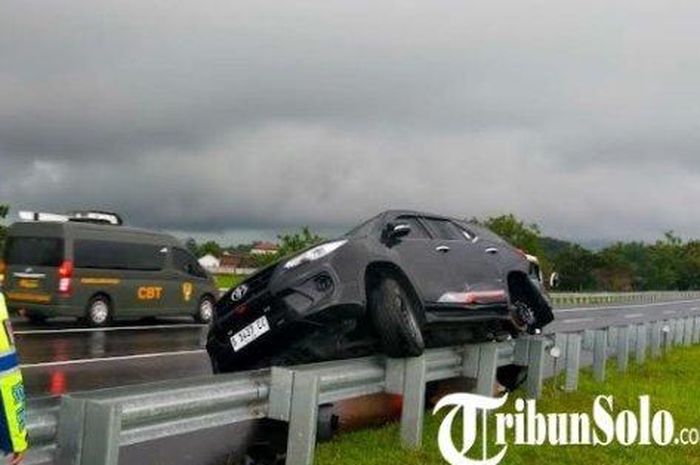 Toyota Fortuner nangkring di atas pembatas jalan Tol Solo-Ngawi