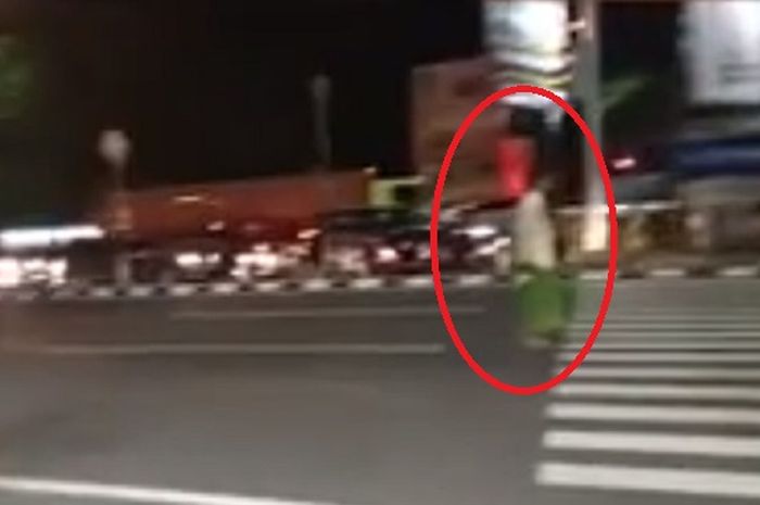 Seorang pria nekat berdiri di tengah jalan