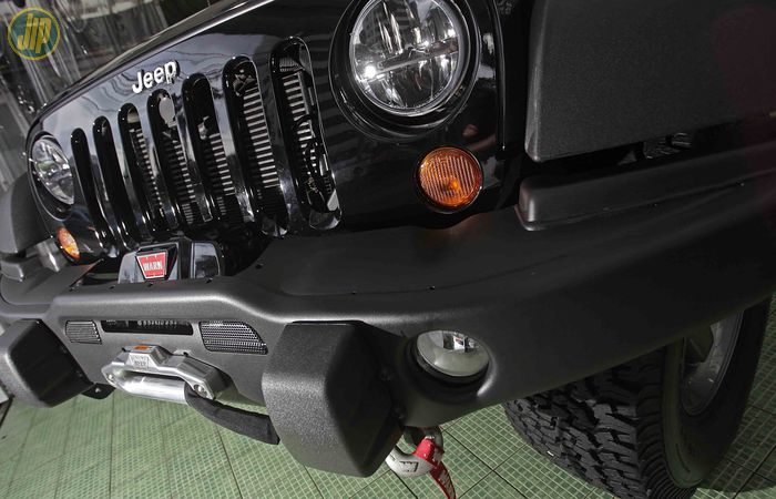 Bemper bawaan Jeep JK ditukar dengan bemper keluaran AEV yang ditambahi winch Warn 9.5 CTI. 