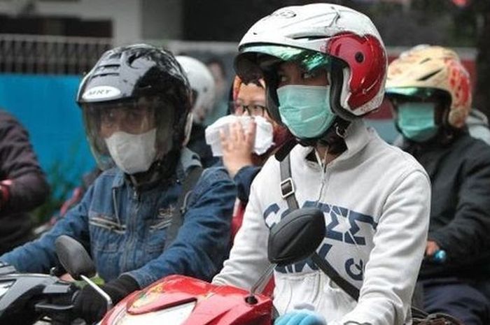 Ilustrasi, seorang pengendara motor terlihat menggunakan earphone.