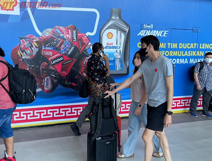 Mau foto di tempat bernuansa MotoGP Indonesia saat tiba di Bandara Internasional Lombok, harus sabar, selain antre juga banyak orang lalu lalang