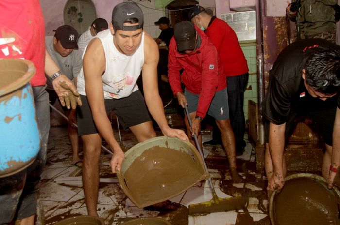 Sean Gelael membersihkan lumpur di dalam rumah warga di Tebet, Jakarta Selatan yang sempat kerendam banjir 
