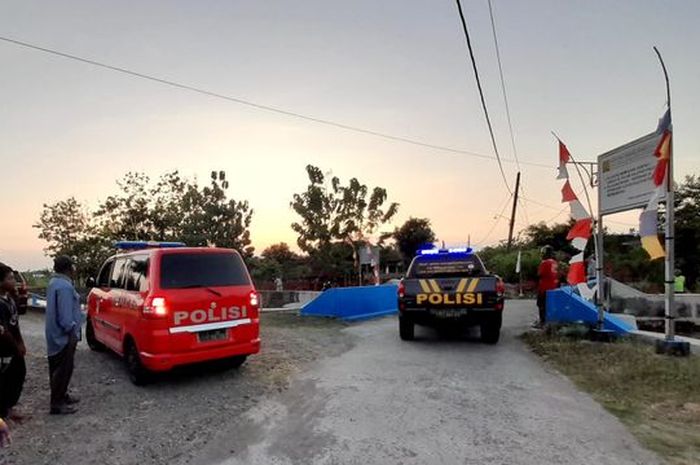 Polisi melakukan oleh TKP terkait penemuan mayat pria berhelm biru muda di saluran air di daerah Wonogiri, Jawa Tengah. 
