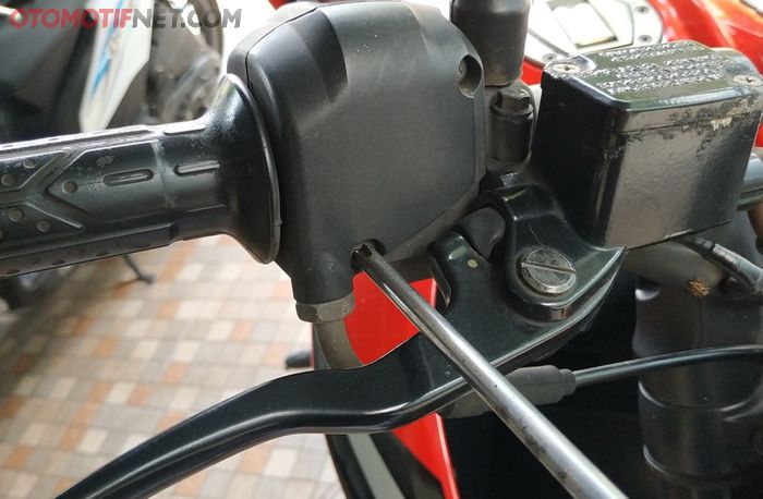 Gunakan obeng plus untuk membuka panel sakelar Kawasaki Bajaj Pulsar 200NS