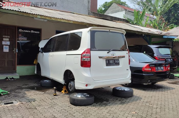 Ilsutrasi Toyota Nav1 sedang servis sistem pengereman, kaki-kaki dalam kondisi menggantung