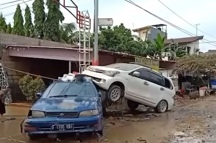Toyota Avanza milik Suhardi yang menindih sedan biru pasca banjir di Pondok Gede Permai, Jatiasih, kota Bekasi