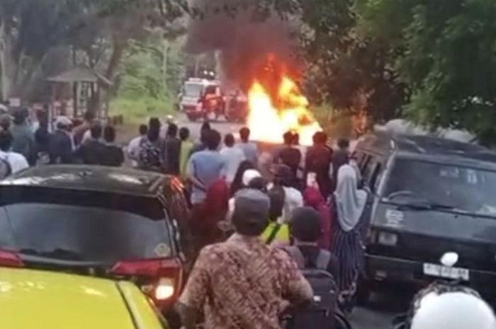 Sedan BMW dikepung api dan jadi tontonan warga yang melintas. Ini awal mulanya