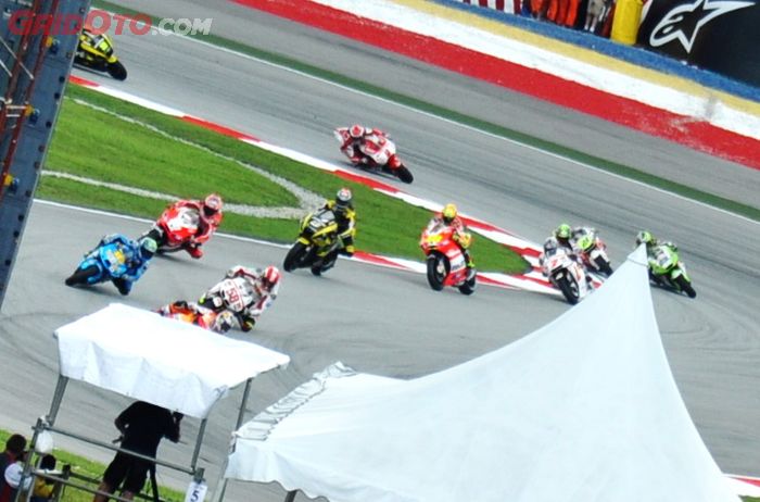 Marco Simoncelli (kanan depan) berebut posisi di tikungan kedua sirkuit Sepang dengan pembalap Suzuki di MotoGP Malaysia 2011