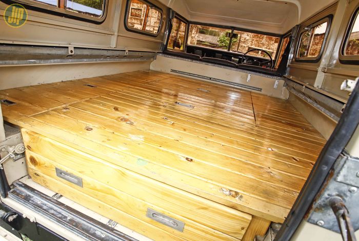 Kabin belakang Land Rover Series IIA dipasangi alas kayu untuk area istirahat.