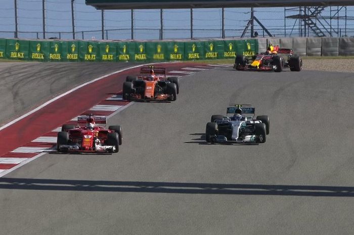 Sebastian Vettel (depan) ketika menyalip pembalap Mercedes Valtteri Botas untuk menempati urutan ketiga