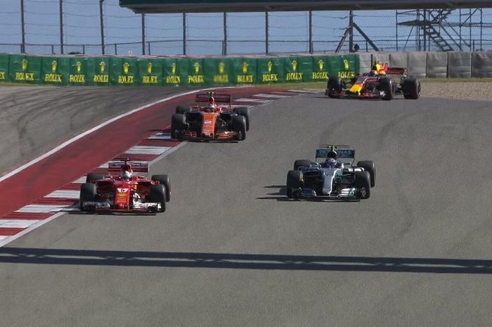 Sebastian Vettel (depan) ketika menyalip pembalap Mercedes Valtteri Botas untuk menempati urutan ketiga