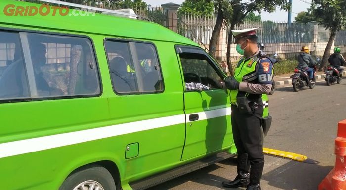 Petugas Kepolisian memeriksa angkutan umum saat PSBB
