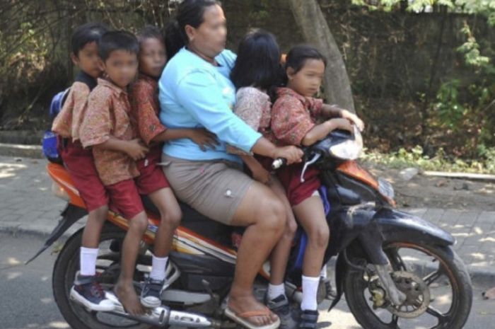 Ilustrasi emak-emak naik motor bonceng anak enggak pakai helm