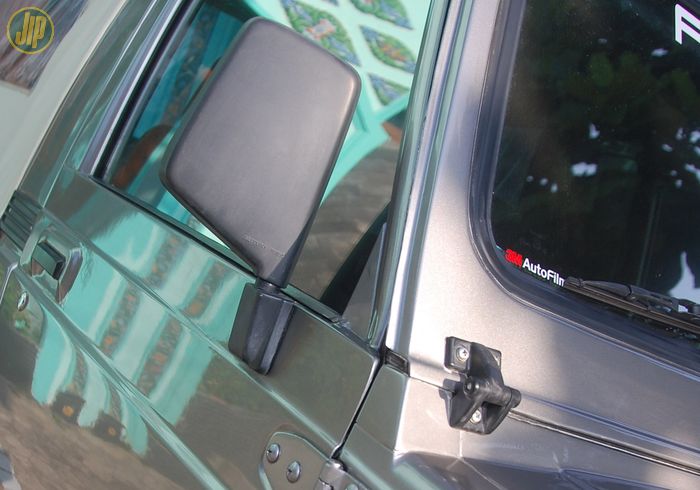 Suzuki Jimny LWB setir kiri ini dipasangi spion dari JA71, frame kaca dipasangi milik Suzuki Sierra mengikuti Maruti Gypsy. 