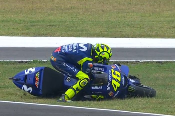 Valentino Rossi mengangkat motornya setelah 'dijatuhkan' Marc Marquez